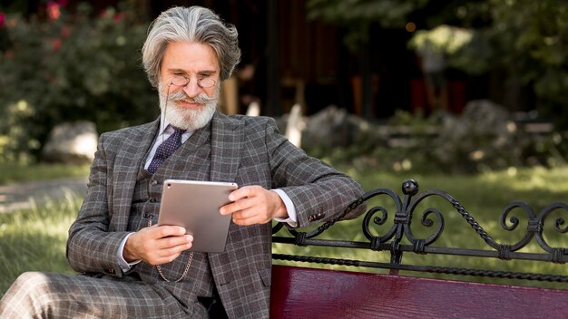 Elegant mature male holding tablet