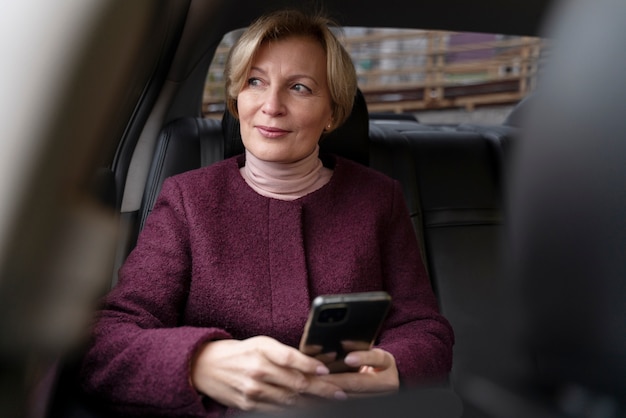 Elegant mature woman sitting in a taxi