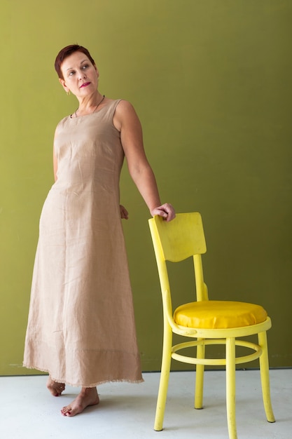 Free photo elegant mature woman with a yellow chair