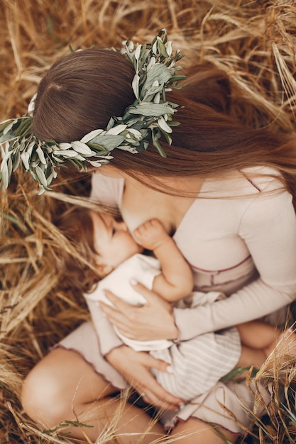 Free photo elegant mother with cute little daughter in a field