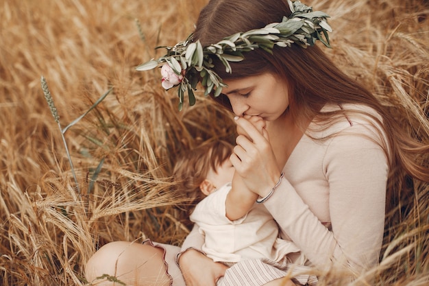 Madre elegante con la piccola figlia sveglia in un campo