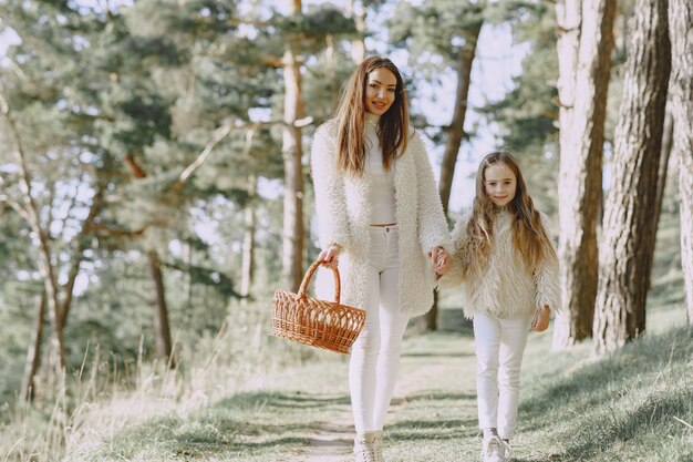 Elegant mother with daughter in a summer forest