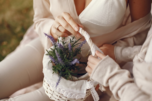 Madre elegante con la figlia in una foresta di estate