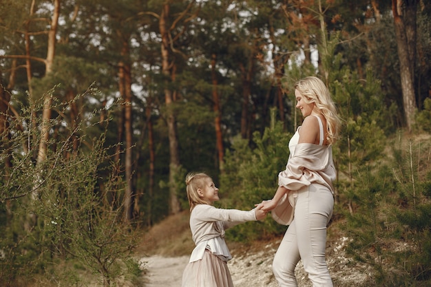 Elegant mother with daughter in a summer forest