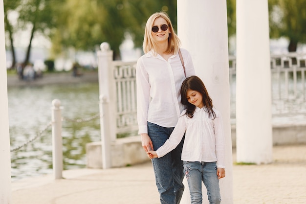 Elegant mother with daughter in a summer forest