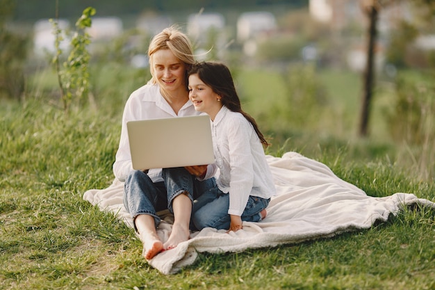 Elegant mother with daughter in a summer forest