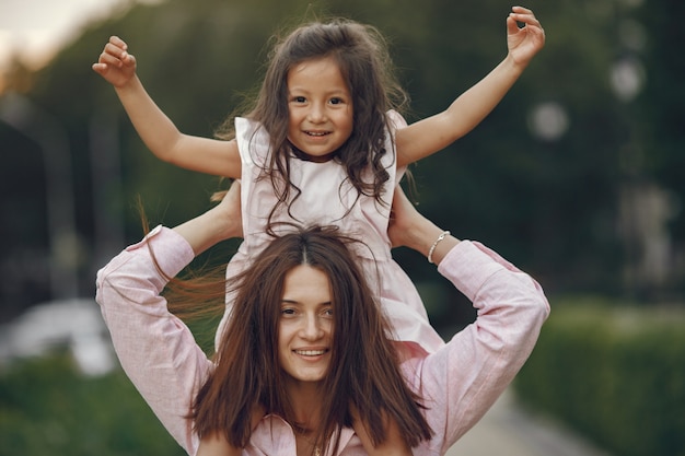 Free photo elegant mother with daughter in a summer park