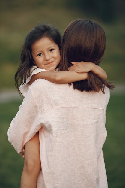 Free photo elegant mother with daughter in a summer park