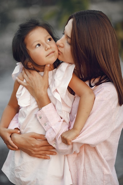 Elegant mother with daughter walks by the water