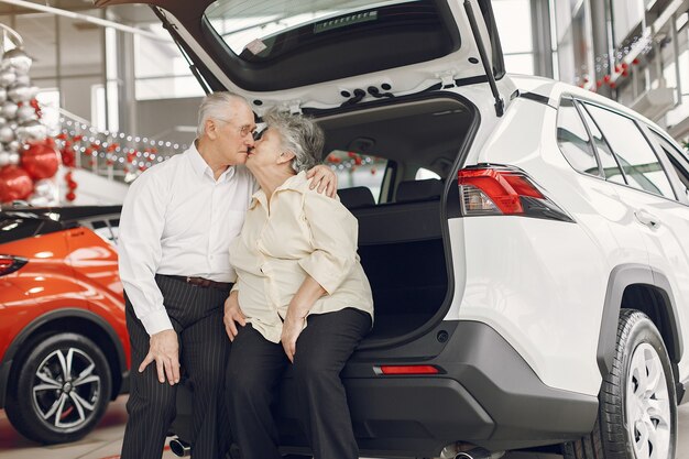 Elegant old couple in a car salon