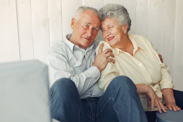 Free photo elegant old couple sitting at home on a foor