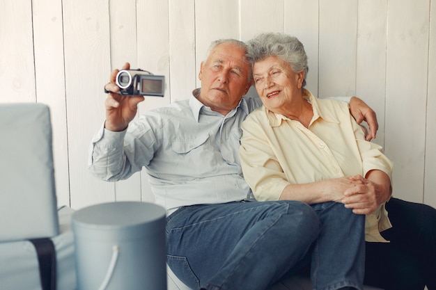 自宅で座っていると、カメラを使用してエレガントな老夫婦