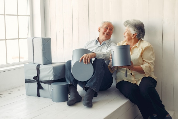 Elegant old couple sitting at home with christmas gifts