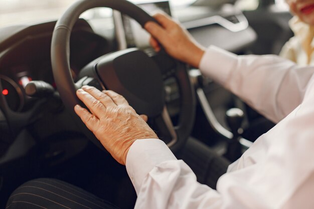 Elegant old man in a car salon