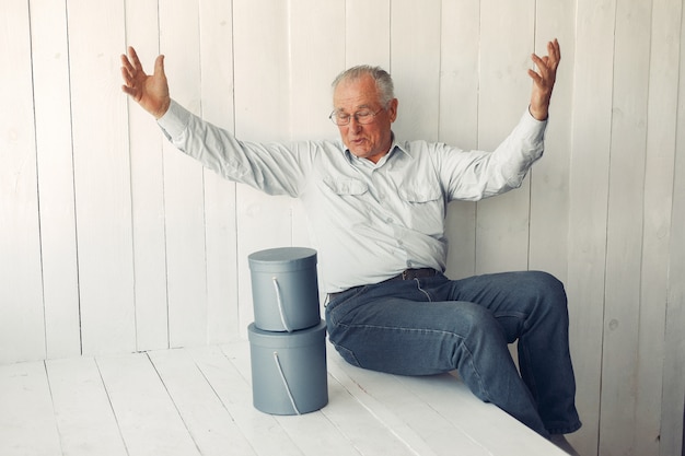 Free photo elegant old man sitting at home with christmas presents