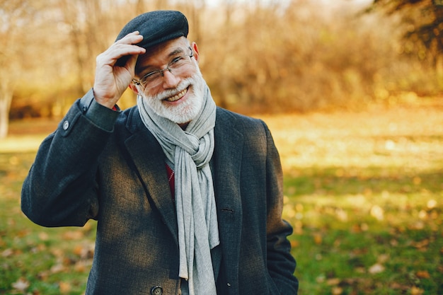 Elegant old man in a sunny autumn park 