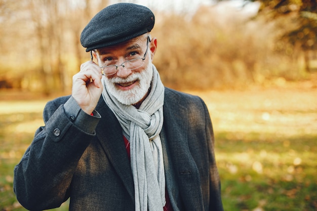 Elegant old man in a sunny autumn park 