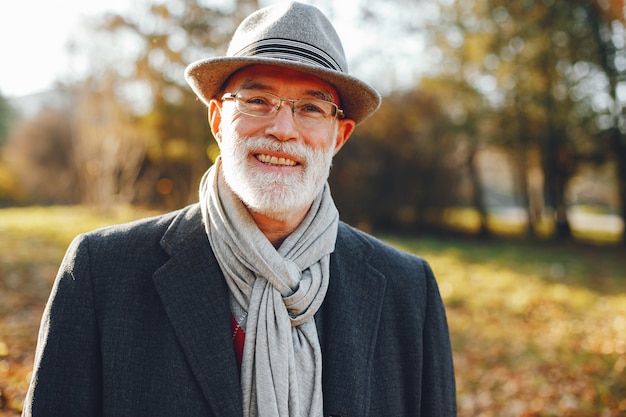 Elegant old man in a sunny autumn park 