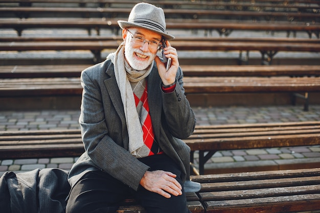 Free photo elegant old man in a sunny autumn park