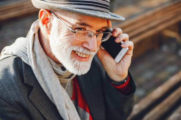 Elegant old man in a sunny autumn park 