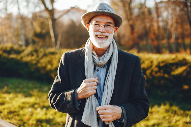 Elegant old man in a sunny autumn park