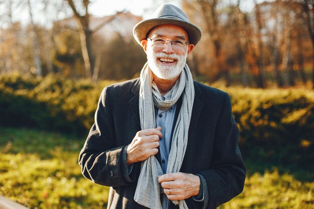 Elegant old man in a sunny autumn park 