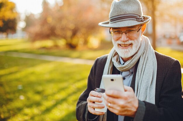 Elegant old man in a sunny autumn park 