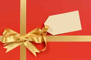 Free photo elegant red gift with a golden bow and tag