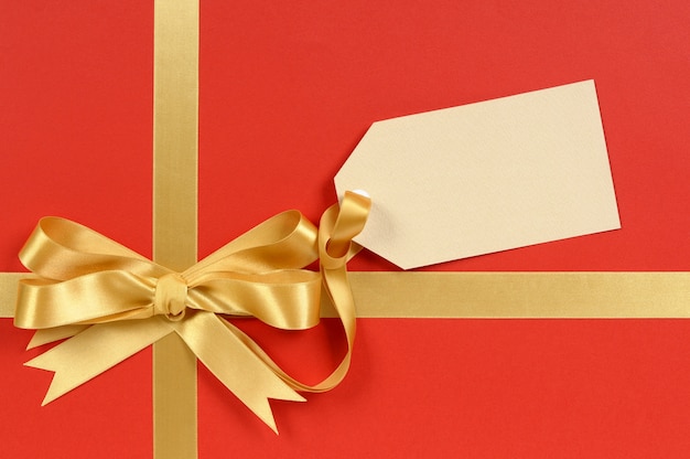 Elegant red gift with a golden bow and tag 