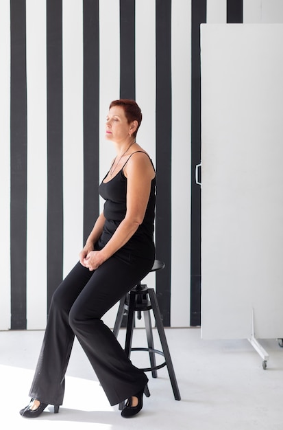 Elegant senior lady sitting on a stool