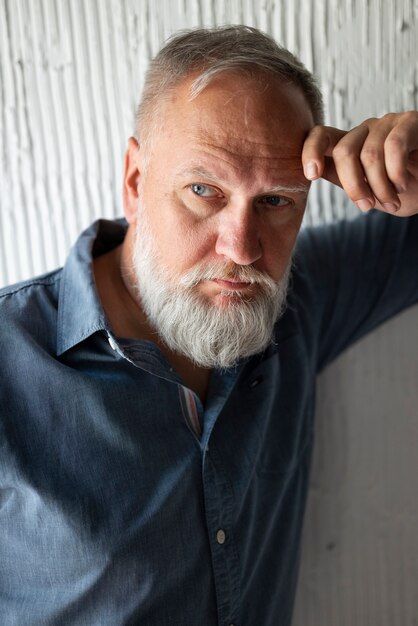 Elegant senior man posing in blue shirt