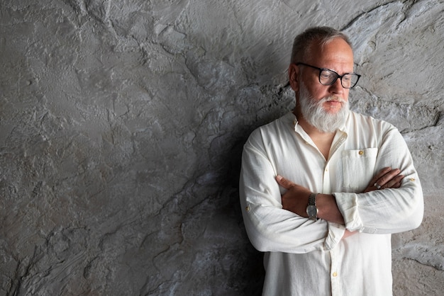 Free photo elegant senior man posing in glasses and white shirt