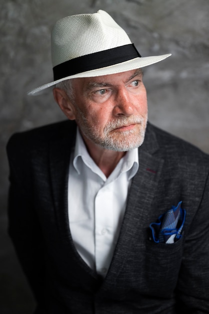 Elegant senior man posing in suit and hat