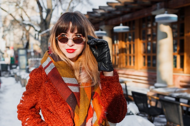 Elegant smiling woman in retro glasses posing outdoor