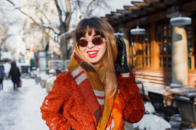 Elegant smiling woman in retro glasses posing outdoor