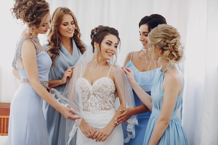 Free Photo elegant and stylish bride along with her four friends in blue dresses standing in a room