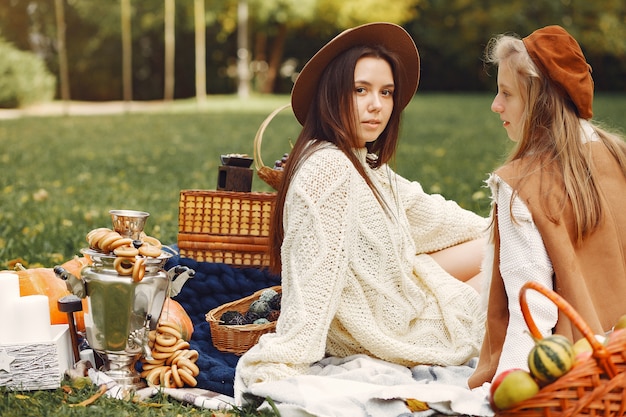 Elegant and stylish girls sitting in a autumn park