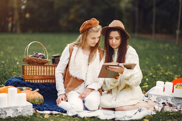 Elegant and stylish girls sitting in a autumn park