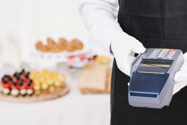 Elegant waiter holding a dataphone