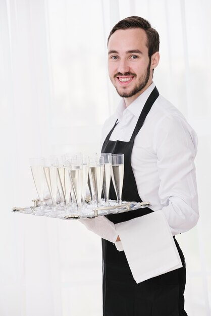 Элегантный официант подает бокалы для шампанского