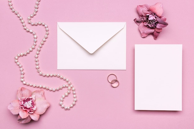 Free photo elegant wedding invitation with pearls on the table