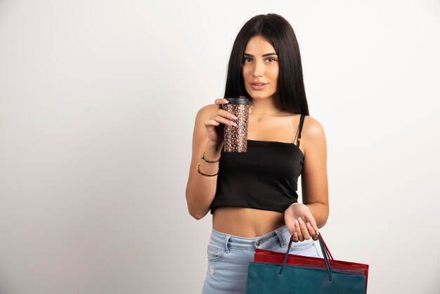 Elegant woman in black top holding bags and coffee. High quality photo