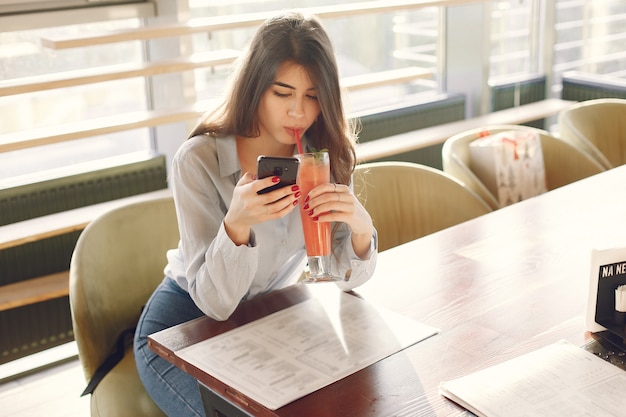 カフェで時間を過ごすブルーのブラウスでエレガントな女性