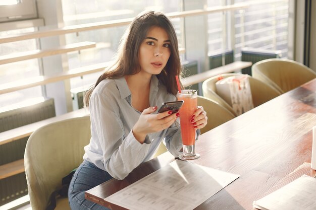 Elegant woman in a blue blouse spending time in a cafe