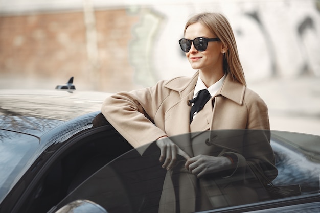 Elegant woman in a brown coat in a spring city