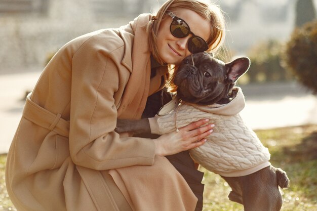 Elegant woman in a brown coat with black bulldog