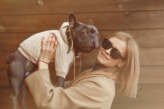 Donna elegante in un cappotto marrone con bulldog nero