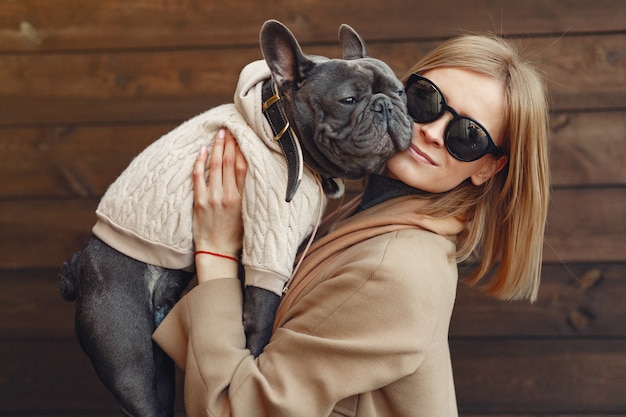 Donna elegante in un cappotto marrone con bulldog nero