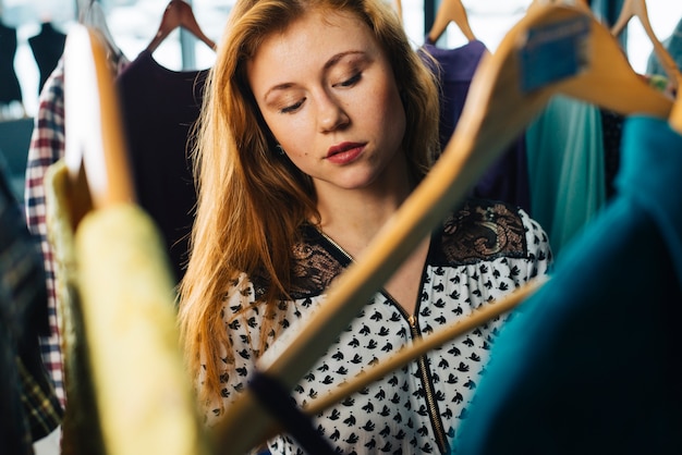 Foto gratuita donna elegante che sceglie i vestiti in negozio