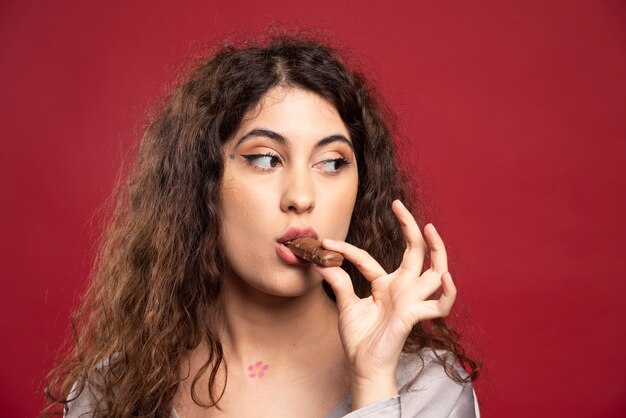 Elegant woman eating chocolate.